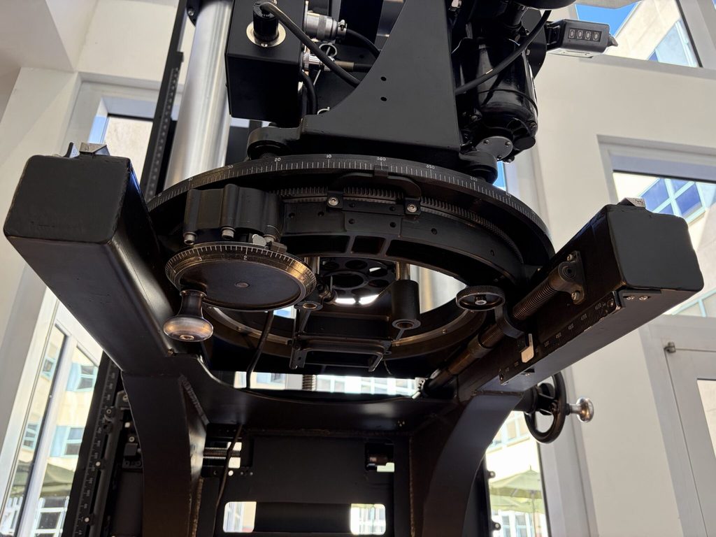 Vue d'ensemble d'une caméra multiplane Disney historique exposée dans un bâtiment, avec sa structure métallique verticale, ses différents niveaux de prise de vue et ses dispositifs de réglage.